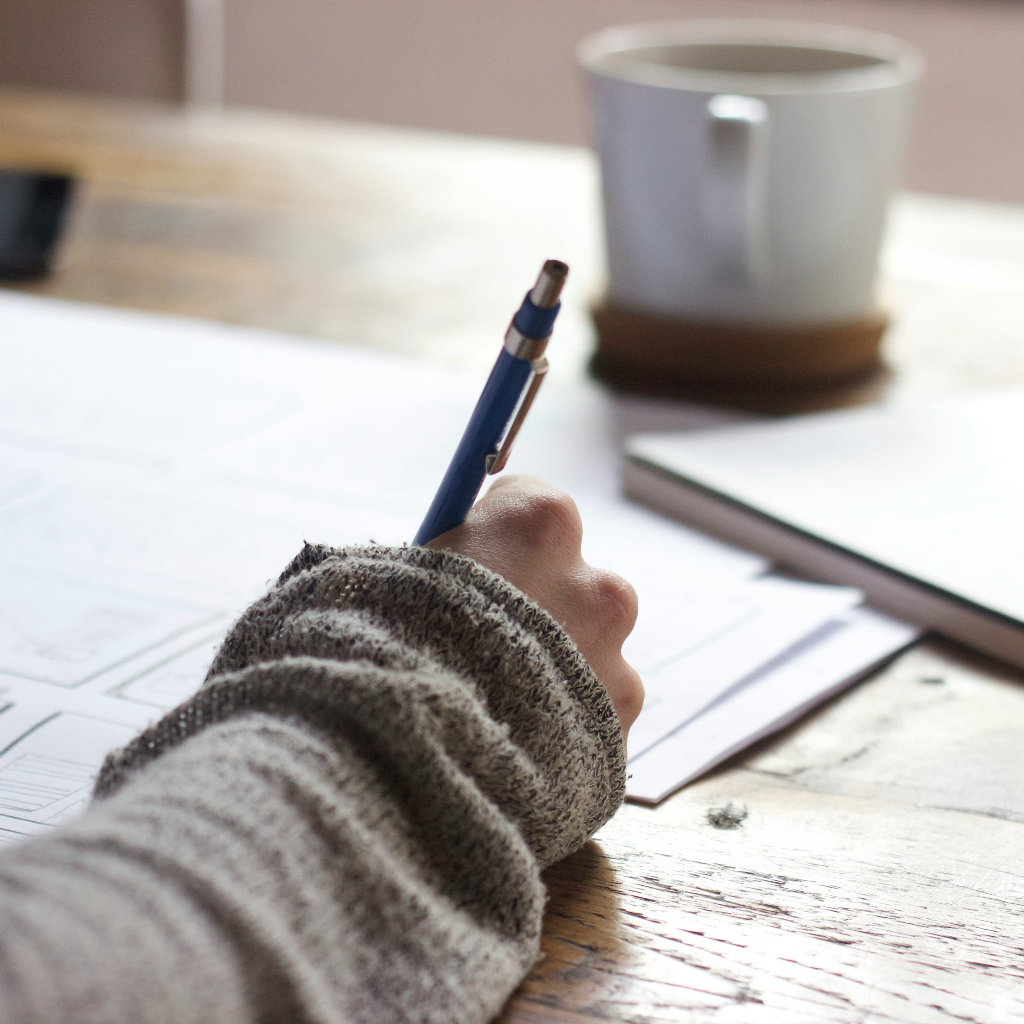 Person writing in their journal as a part of their self-care routine