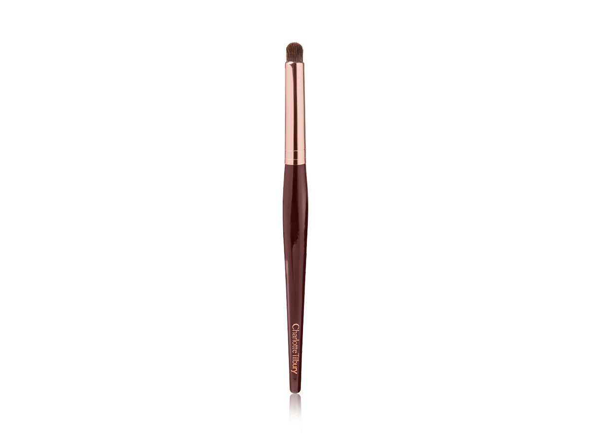An eyeshadow smudging brush in a rose gold and dark crimson colour scheme. 
