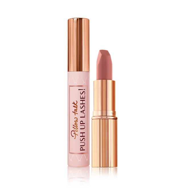 A black-coloured mascara with a nude pink tube and a gold-coloured lid and an open, nude pink lipstick in a gold-coloured tube.