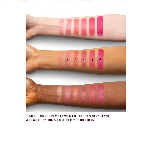 Fair, tan, and deep-tone arms with seven matte lipsticks in shades of pink and peach. 