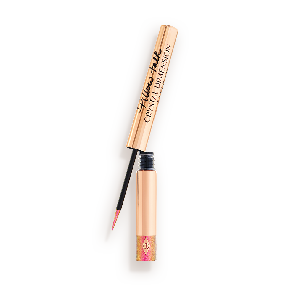 Delineador de ojos brillante de color rosa vivo en un tubo dorado con una varita fina de color negro y dorado. 