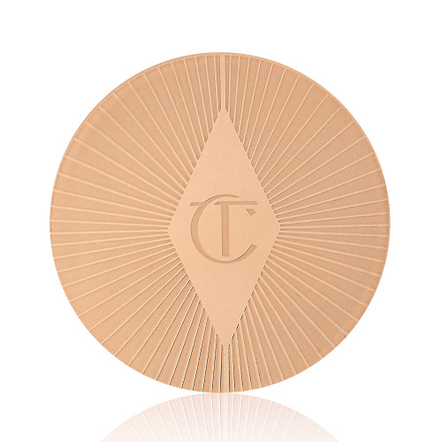 Close-up of a gold-coloured lip scrub lid with a starburst pattern on top and the CT logo printed in the middle.