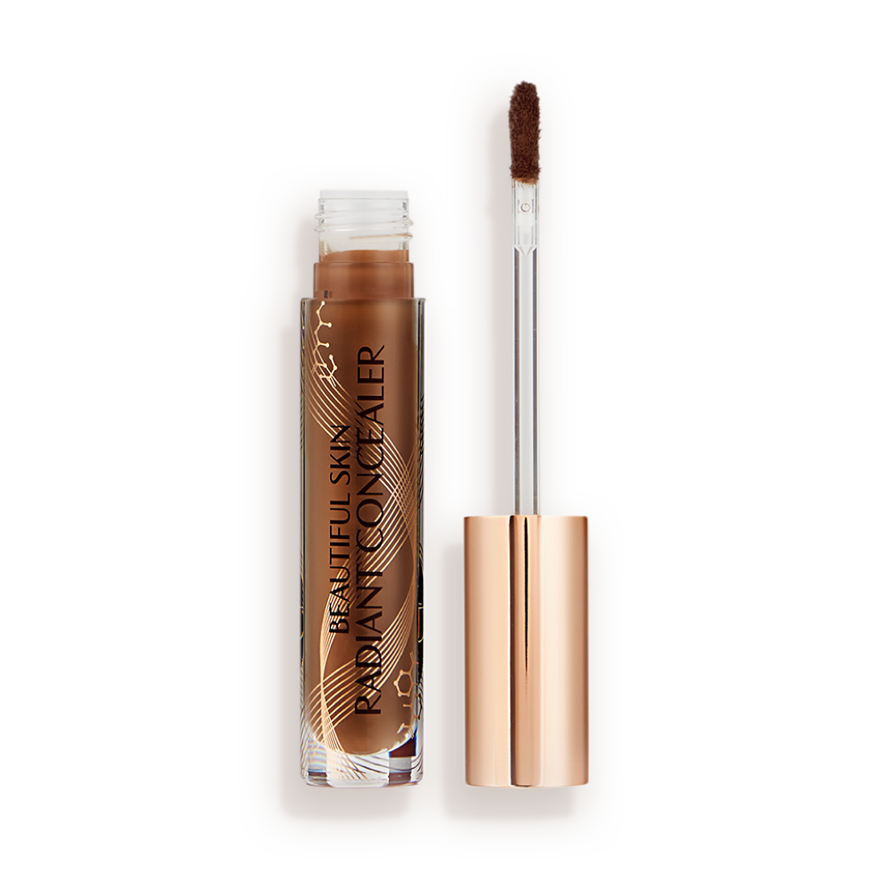 Dark brown radiant concealer in a glass tube with its gold-coloured lid with a doe-foot end next to it, and text on the tube that reads, 'Beautiful Skin Concealer'