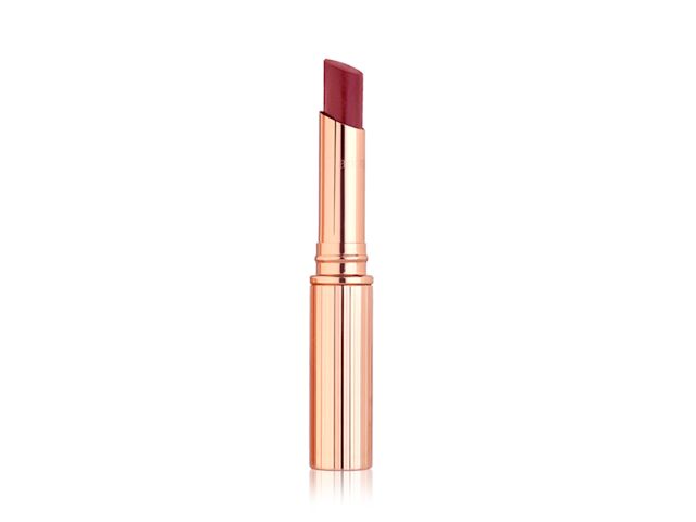 An open, berry rose glossy lipstick in metallic, golden-coloured packaging. 