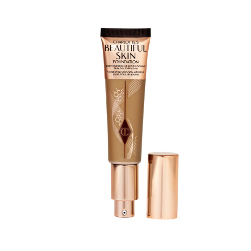 An open foundation wand in gold packaging with a pump dispenser and a dark-sandy-brown-coloured body to show the shade of the foundation inside. 