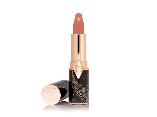 An open lipstick in a  peachy nude-rose shade with a satin finish with its lid next to it. 