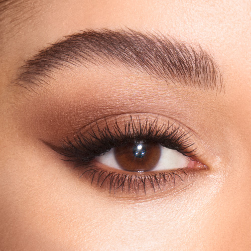 Close-up of a light-tone model's brown eye with shimmery nude brown and fawn eye makeup. 