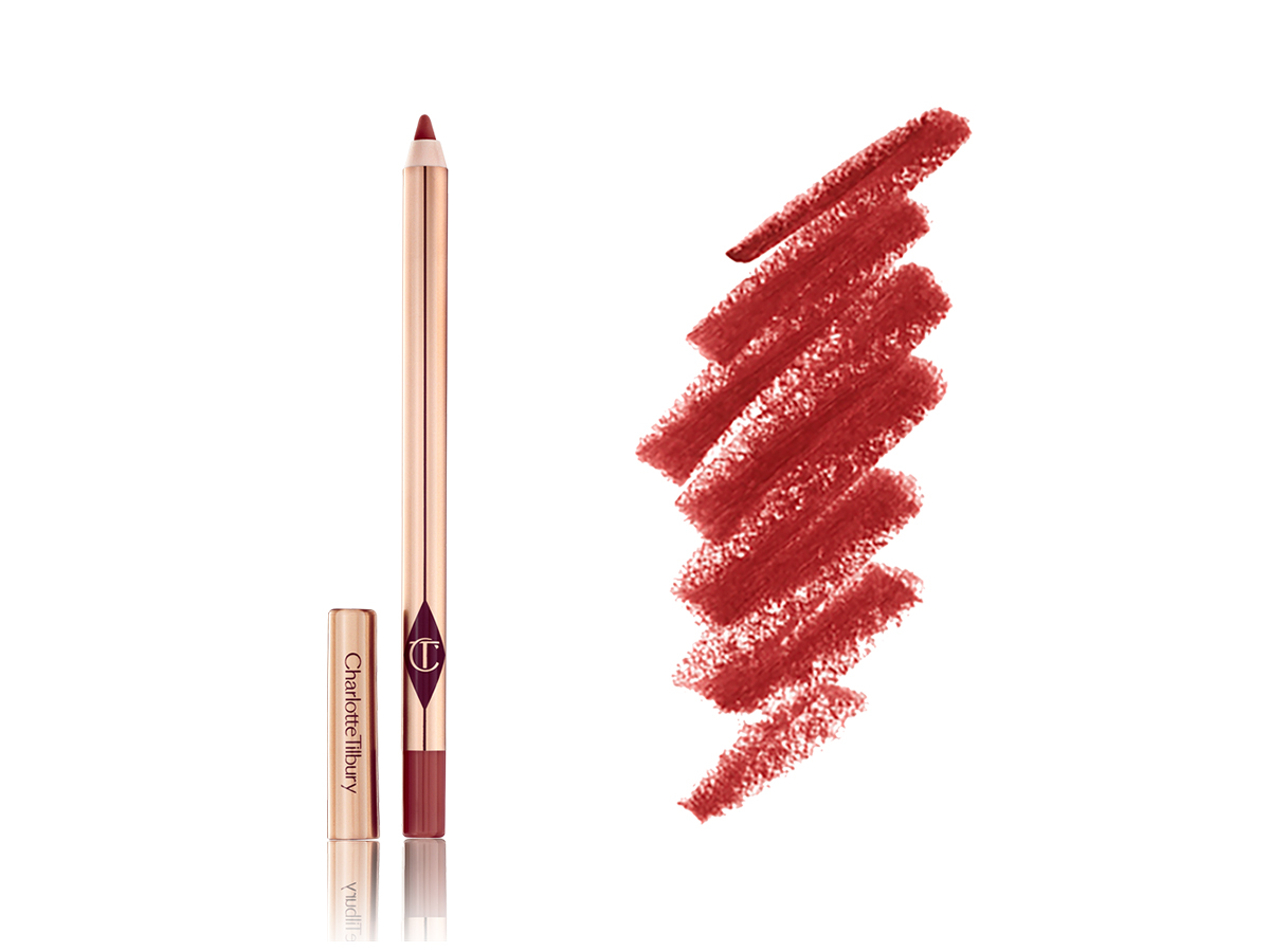 An open lip liner pencil in a berry-rose shade with its lid next to it in gold-coloured packaging and close-up of its swatch next to the lip liner. 