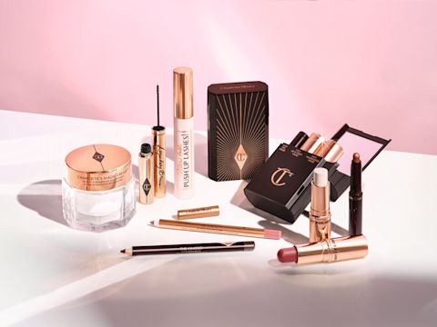 Pearly-white face cream in a glass jar, liquid eyeliner in a golden tube, makeup kit with an eyeshadow stick, lip and cheek stick, and highlighter stick, lip liner pencils, mascara, and eyeliner pen.