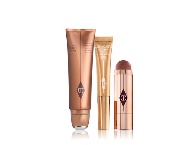 Body highlighter wand in a bronze tube, face highlighter wand in a honey-gold tube, a blush stick in a berry-red shade in gold packaging.
