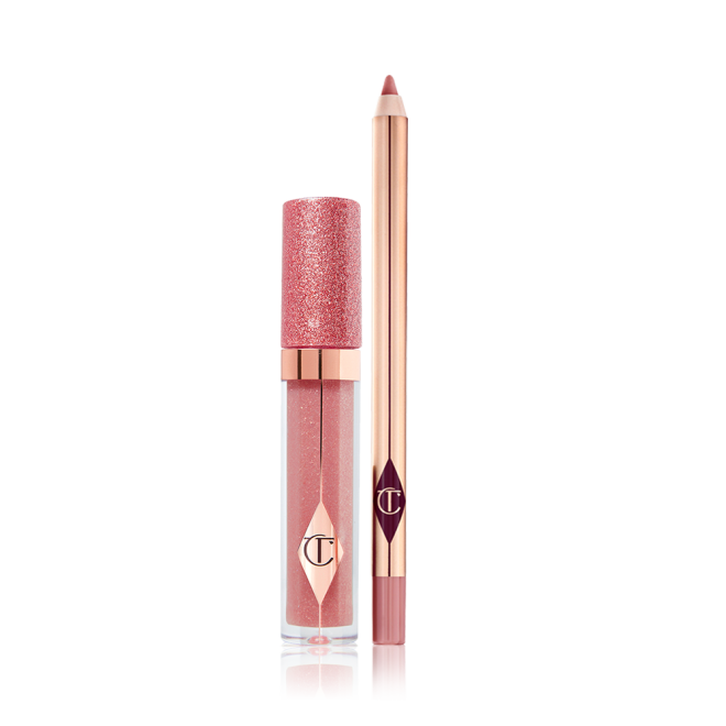 Shimmery lip gloss in a nude pink shade in a glass tube with a glittery lid with an open lip liner pencil in a nude pink shade. 