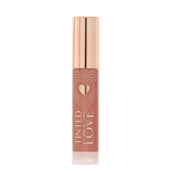 A closed tube of lip and cheek tint in a sheer, tea rose colour with a gold-coloured lid.