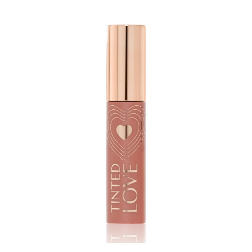 A closed tube of lip and cheek tint in a sheer, tea rose colour with a gold-coloured lid.