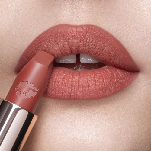 Lips close-up of a fair-tone model wearing a delicate peachy nude matte lipstick.