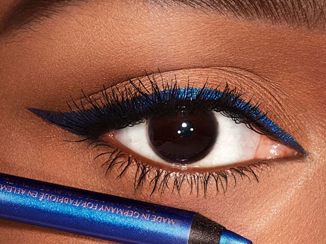 Eye close-up of a deep-tone model with brown eyes wearing royal blue eyeliner in a wing shape. 