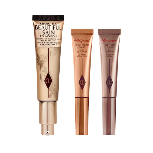 Two, closed liquid contour wands in light brown and chocolate brown next to a foundation wand in gold packaging with a pump dispenser. 
