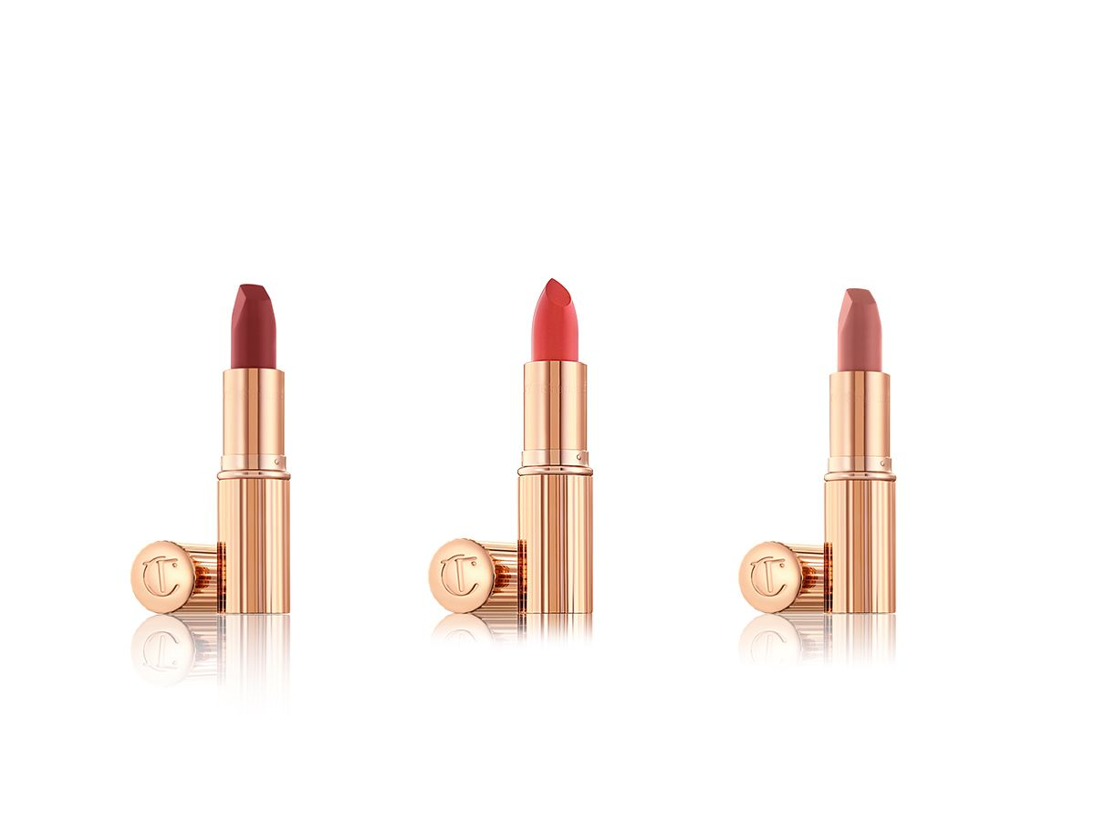 A lipstick trio with metallic, golden-coloured packaging and in shades of red, orange, and nude pink. 