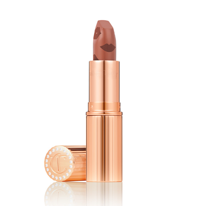  A rosy terracotta coral lipstick with a satin-finish in a gold-coloured tube with its lid next to it.