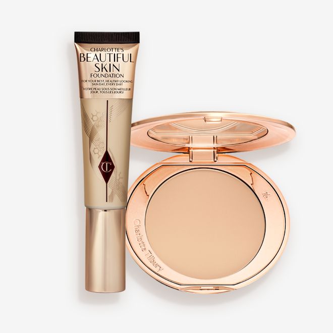 Charlotte's Beautiful Skin Complexion Kit displayed A foundation wand in gold packaging with a brown-beige-coloured body to show the shade of the foundation inside, and a pressed powder compact with a mirrored lid.