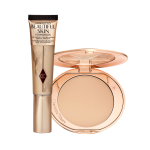 A foundation wand in gold packaging with a brown-beige-coloured body to show the shade of the foundation inside, and a pressed powder compact with a mirrored lid.