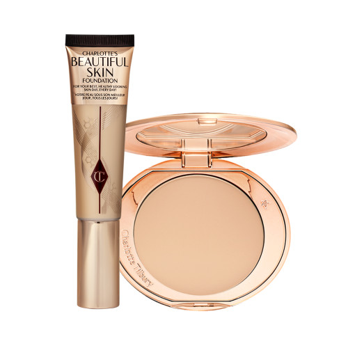 A foundation wand in gold packaging with a brown-beige-coloured body to show the shade of the foundation inside, and a pressed powder compact with a mirrored lid.