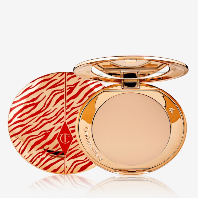Airbrush Flawless Finish Powder in Medium Lunar New year open An open, pressed powder compact for medium skin tones with a mirrored lid, in gold-coloured packaging with red-coloured tiger stripes on the lid.