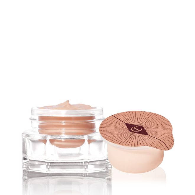 An open, champagne-coloured thick and luscious eye cream in a glass pot with its refill in a petite pot with an easy-to-peel-off cover.