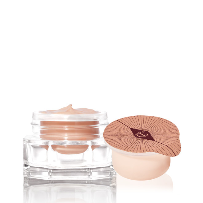An open, champagne-coloured thick and luscious eye cream in a glass pot with its refill in a petite pot with an easy-to-peel-off cover.