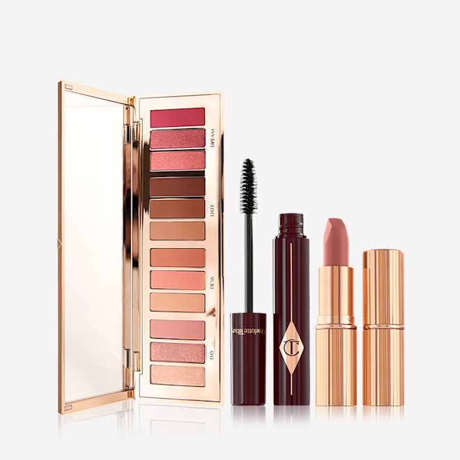 Pillow Talk Instant Eye Palette, Full Fat Lashes, and Pillow Talk Original Lipstick Bundle An open, mirrored-lid eyeshadow palette with nude pink, peach, and brown shades, an open mascara with its applicator next to it, and an open nude pink lipstick with a closed lipstick.