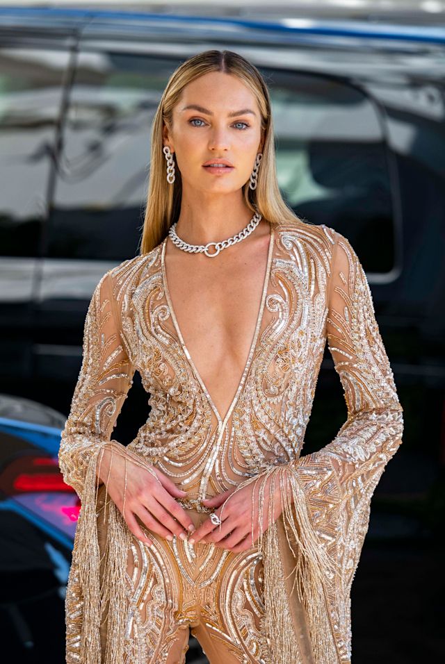 Candace Swanepoel at Cannes Film Festival 2021, wearing a sparkly silver and gold gown with a low-cut neck with a shimmery silver necklace, and soft, glowy nude makeup done using Charlotte Tilbury products.