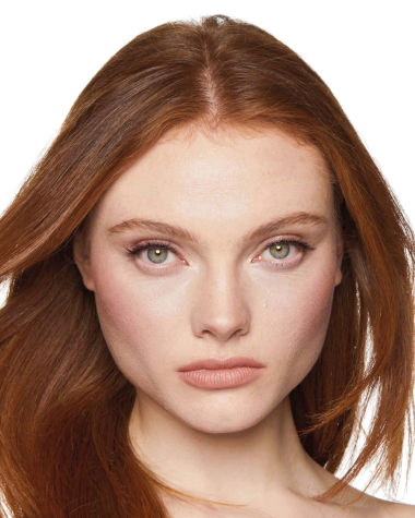 Fair-tone model with grey eyes wearing nude peach lipstick with a berry-rose blush with champagne undertones.