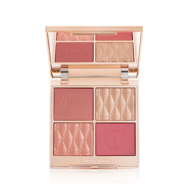 Una paleta facial abierta con sombras de ojos mates y brillantes, coloretes e iluminadores en tonos rosa, rojo y dorado con tapa de espejo.