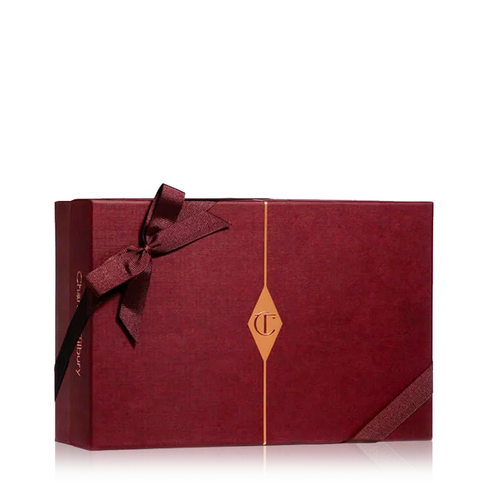 A maroon-coloured gift box with a maroon-coloured bow and the CT logo in golden-colour printed on the box. 