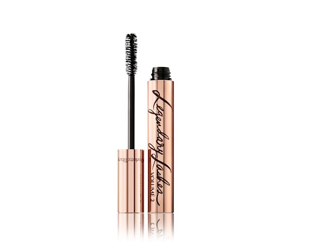 Black-coloured mascara in golden packaging opened with its applicator next to it.