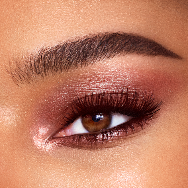 Eyes to Mesmerise in Sunset Rose on brown eye close-up Close-up of a single brown eye with shimmery, rose-gold-coloured cream eyeshadow.