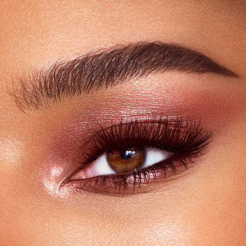 Close-up of a single brown eye with shimmery, rose-gold-coloured cream eyeshadow. 