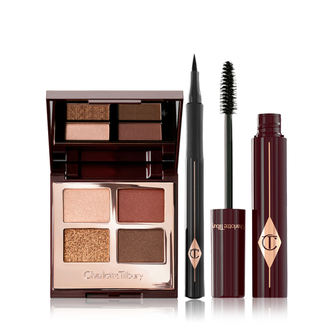 An open, mirrored-lid eyeshadow palette in matte and shimmery brown and gold shades, an open black eyeliner pen, and an open mascara with its applicator in a dark-crimson colour scheme. 