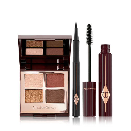 An open, mirrored-lid eyeshadow palette in matte and shimmery brown and gold shades, an open black eyeliner pen, and an open mascara with its applicator in a dark-crimson colour scheme. 