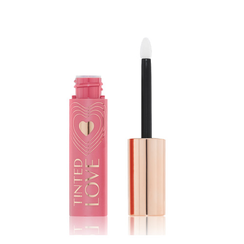 An open lip and cheek tint in a rosy pink shade with a pink-coloured bottle with a white and gold-coloured doe-foot applicator. 