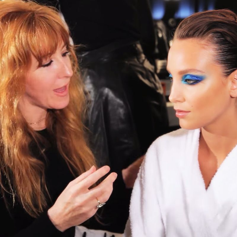 Charlotte Tilbury with a medium-tone brunette model wearing a peacock-themed eye look. 
