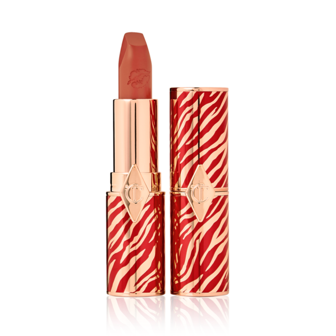 Two lipsticks, one with its lid and one without, in delicate peachy nude colour with a matte finish. 