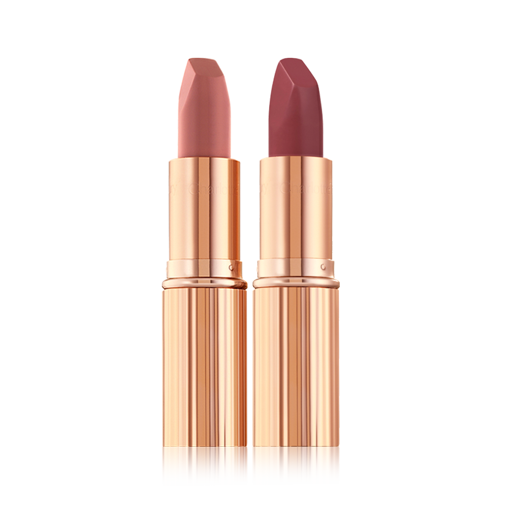Two matte lipsticks, one a nude pink and the other a berry-rose shade in golden, metallic tubes with their lids removed. 