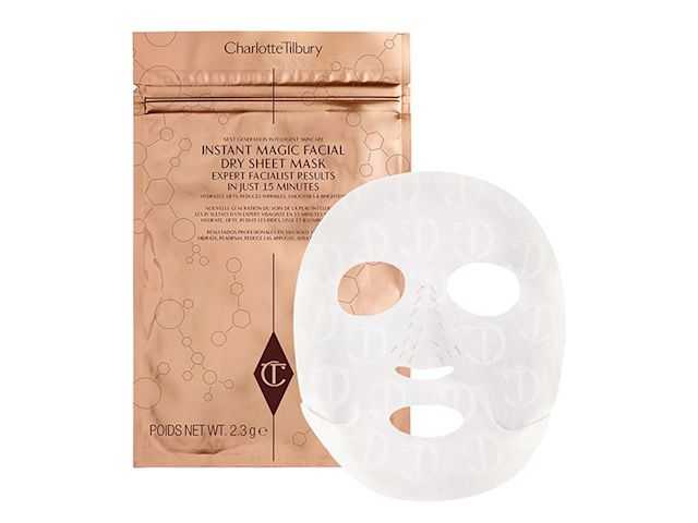 An open, sheet mask in a textured fabric material with golden, foil packaging. 