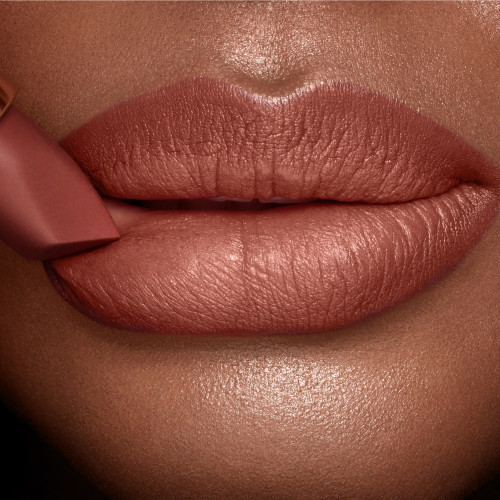 Lips close-up of a deep-tone model wearing a deep, sultry rose-brown nude lipstick with a matte finish.
