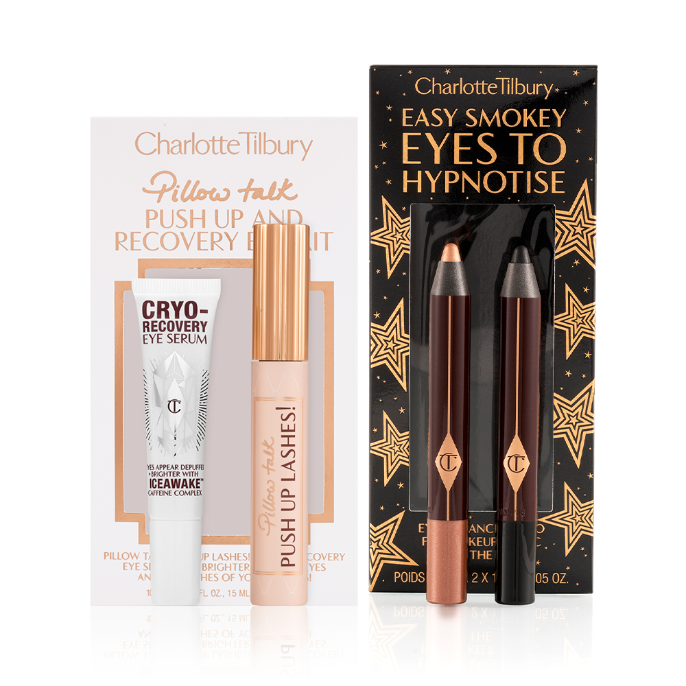 Eye serum in a white-coloured bottle, black mascara in a nude pink tube with a gold-coloured lid, and two chubby eyeshadow pencils in rose gold and black.