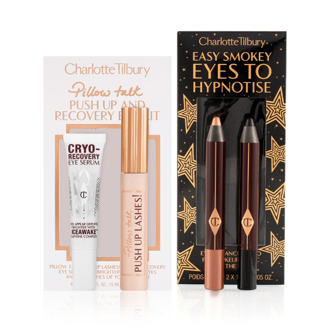Eye serum in a white-coloured bottle, black mascara in a nude pink tube with a gold-coloured lid, and two chubby eyeshadow pencils in rose gold and black.