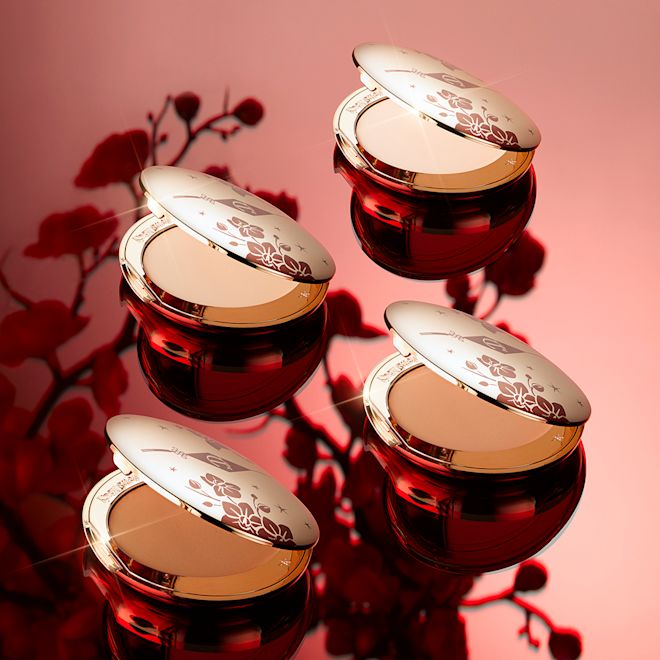 Airbrush Flawless Finish Powder in Fair Lunar New year collection open Collection of open, pressed powder compacts for fair, tan light, and deep skin tones with mirrored lids, in gold-coloured packaging with red-coloured tiger stripes on the lids.