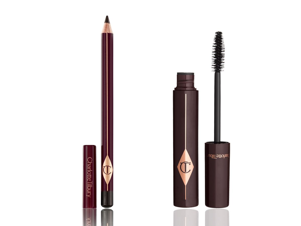An open eyeliner pencil with its lid next to it with an open mascara tube with its applicator next to it, both in dark crimson packaging. 