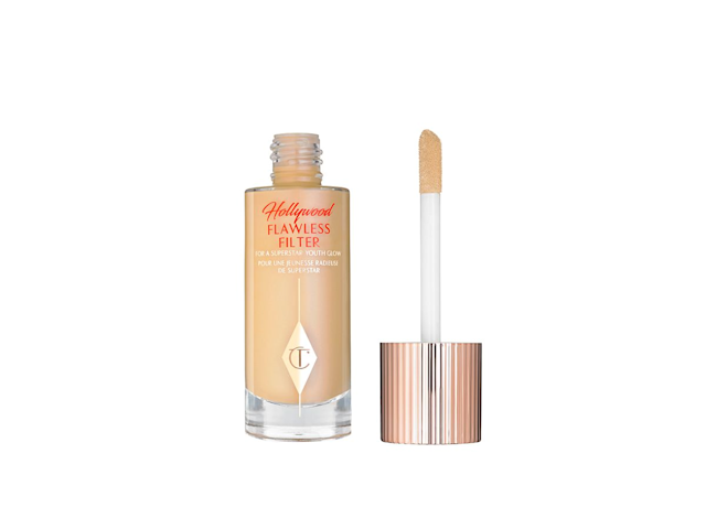 An open, luminising primer in a glass bottle with its doe-foot applicator next to it. 