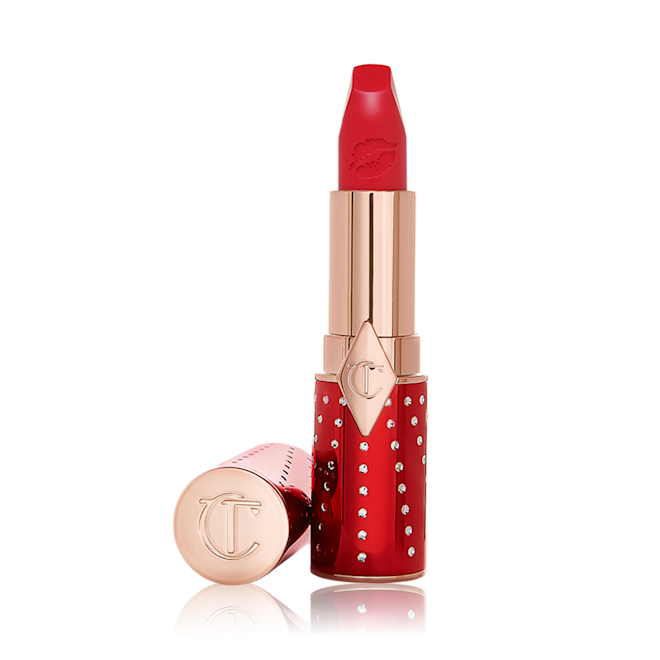 Matte Revolution lipstick in Lucky Cherry lid removed An open lipstick in a matte, bright cherry red shade in a red and gold-coloured tube.